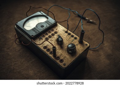 Old electrical appliance for checking and measuring the current level with wires and toggle switches on a wooden table in a retro style