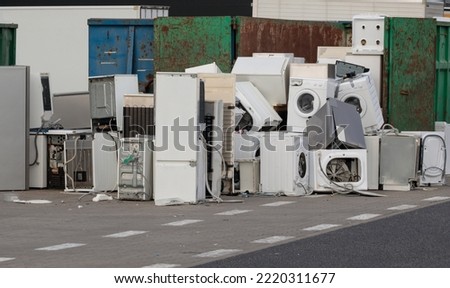 Old electrical appliances in container of recycling center. Electronic waste for recycling. Discarded household appliances in the garbage container.