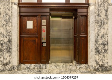 Old Elevator With Metal Doors And Wood Grain Paneling