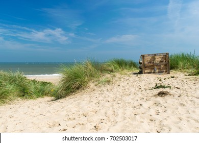 A old and empty bench on the beach looking out to sea on a sunny day, Caister On Sea, England