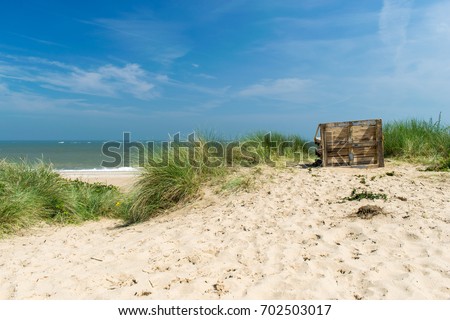 A old and empty bench on the beach looking out to sea on a sunny day, Caister On Sea, England