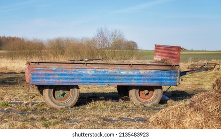 An Old Empty Tractor Trailer On A Field.