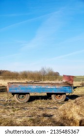 An Old Empty Tractor Trailer On A Field.