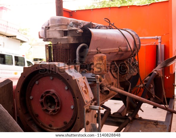 The old engine is idle and has a background\
toward orange.