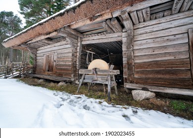 Old Estonian peasant's farm houses and the whetstone in front of it. Tool which was used for sharpening sharp objects. Log cabin which was used as animal and tool shed. New straw roof of a farm house - Powered by Shutterstock