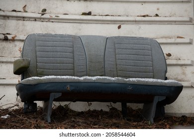 Old Fabric Car Bench Seat Dusted With Snow Sitting Outside In Front Of White Metal Sea Can With Paint Peeling  Fall Coloured Leaves On The Ground Horizontal Format Grunge Background Empty Chair 