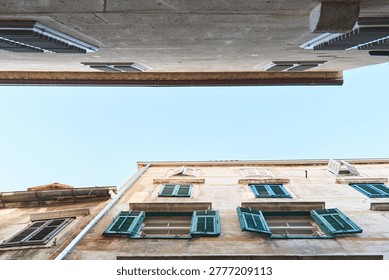 Old facade showing different windows and green shutters from a building in croatia