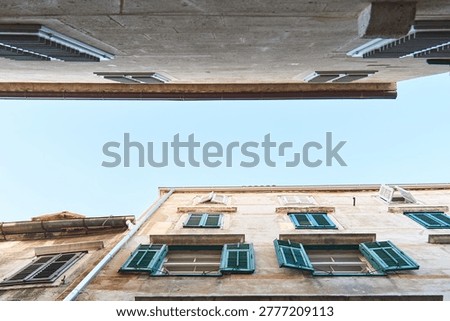 Old facade showing different windows and green shutters from a building in croatia
