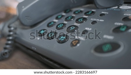 Old facsimile button phone, handset removed. Red-blue flashing light. Concept of emergency, emergency services, no one answering. Close-up.