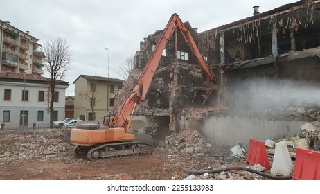 Old factory demolition by excavator