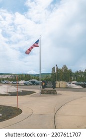 Old Faithful Geyser, Wyoming, USA. May 2021. Old Faithful Visitor Center Sign With American Flag 