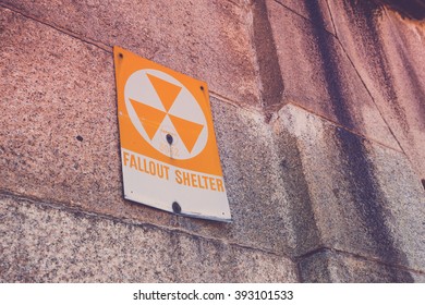 A old fallout shelter sign on the side of an old military fort.