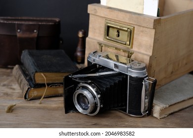 old family photos 50s, 40s, retro camera, books on wooden table, concept of genealogy, memory of ancestors, family tree, childhood memories, home archive - Shutterstock ID 2046983582