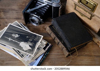 old family photos 50s, 40s, retro camera, books on wooden table, concept of genealogy, memory of ancestors, family tree, childhood memories, home archive
