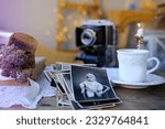 old family photos in vintage interior, stack nostalgic sentimental pictures, vintage photographs 50s, 40s, retro accordion camera on wooden table, concept genealogy, memory ancestors, family tree