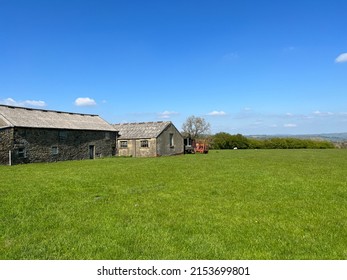 Old Farm Buildings And Machinery, In A Large Field, With Hills In The Far Distance Near, Cowling, UK