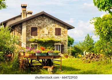 An Old Farm In The Italian Countryside With Flowers In Its Garden