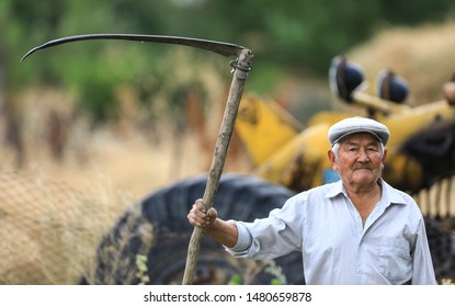 Old Farmer With Scythe On A Farm