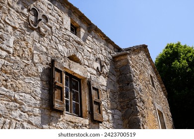 old farmhouse facade with typical stone wall and classic wooden shutter window from central France caussenarde in Lozere Hures la Parade village