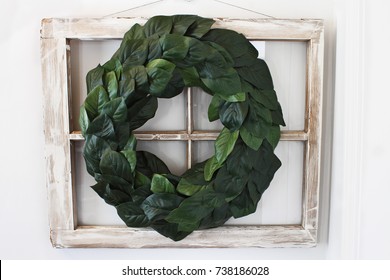 Old Farmhouse Window Decorated With A Homemade Magnolia Leaf Wreath Hung On An Interior Wall.