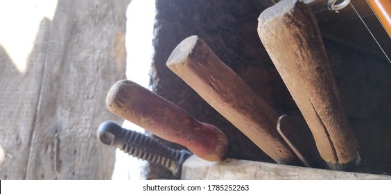 Old Farming Tools At Walls Of The House. Barn Tool Handles.