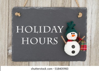 Old Fashion Christmas Store Message, A Retro Chalkboard With A Snowman Hanging On Weathered Wood Background With Text Holiday Hours