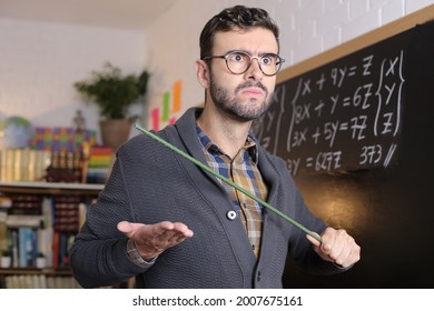 Old Fashioned Angry Teacher Holding Stick In Classroom