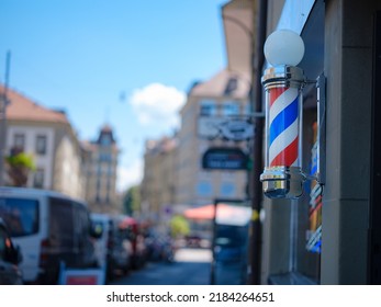 Old Fashioned Barbershop Pole over city street. International barbershop pole sign. A barber pole calling for people at street. Vintage barbershop. Salon