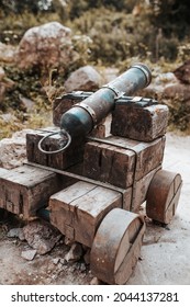 An Old Fashioned Cannon With A Wooden Carriage And A Cast Iron Barrel For Firing Cannonballs