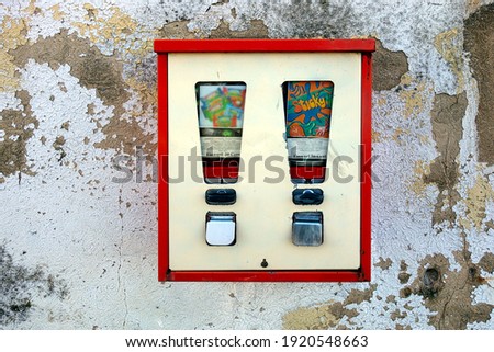 Old fashioned chewing bubble gum machine on an old crumbling wall. 