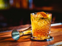 Old fashioned cocktail and beaker on the bar counter, a Food & Drink Photo by Kateryna Mostova