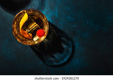 Old fashioned cocktail with bourbon whiskey, cherry and orange peel garnish, blue table, copy space, top view - Powered by Shutterstock