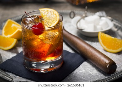 Old Fashioned Cocktail In Vintage Inspired Bar With Liquor Bottles And Ingredients