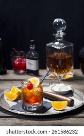 Old Fashioned Cocktail In Vintage Inspired Bar With Liquor Bottles And Ingredients