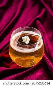 Old Fashioned Cocktail With Whiskey, Classic Old Fashion With A Piece Of Ice On Red Velvet, Retro Crystal Glass Tumbler