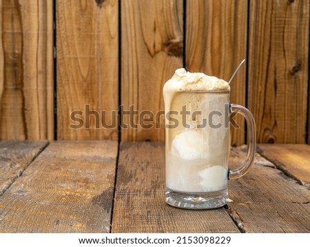 Old Fashioned Frothy Root Beer ice cream float on a rustic wooden background with copy space.