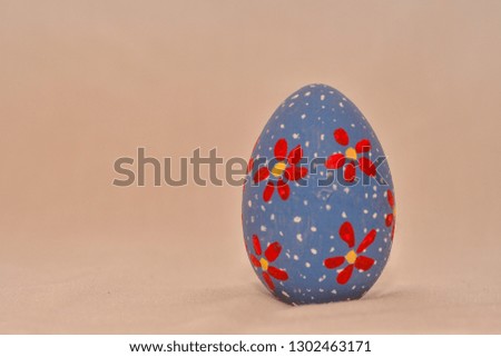 Old fashioned handpainted  Easter egg isolated on beige background.Red Flower