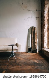 Old Fashioned Interior Big Wooden Window And Mirror, White Sofa In Old Vintage Living Room With Brick Walls.