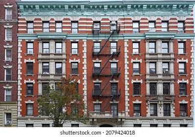 Old Fashioned Manhattan Apartment Building Facade With Ornate Roof Cornice And External Fire Escape Ladders