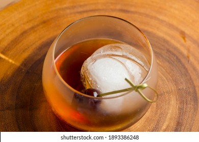 Old fashioned or Manhattan cocktail. Classic American drink with rye whiskey or bourbon, muddled maraschino cherries, oranges and sugar. Shaken, served over ice and garnished with an orange peel.