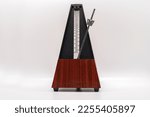 Old fashioned musical metronome isolated on a white background