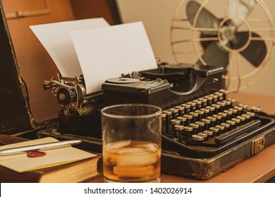 Old Fashioned Office Still-life Setup With Typewriter, Fan, And Glass Of Whiskey.