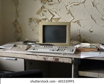 Old Fashioned Personal Computer And Keyboard On A Desk In Front Of A Wall That Is Peeling.                                