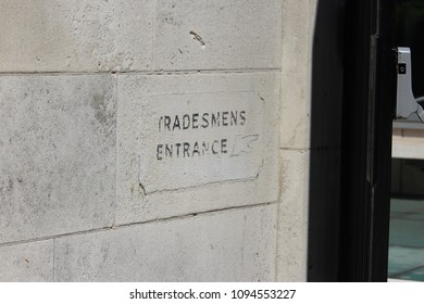 Old fashioned 'Tradesmen Entrance' sign on gatepost in London