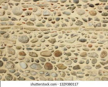Old fashioned and traditional stone wall with natural cobble rocks embedded in it, rural south France. Background, texture photography