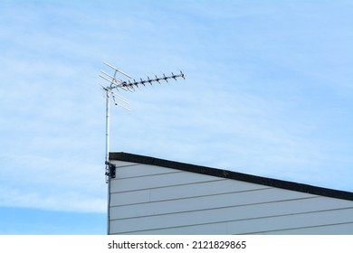 Old fashioned TV aerial mounted on the edge of a roof in England.