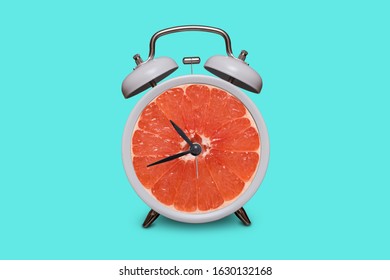 Old fashioned white alarm clock. Grapefruit instead of a dial