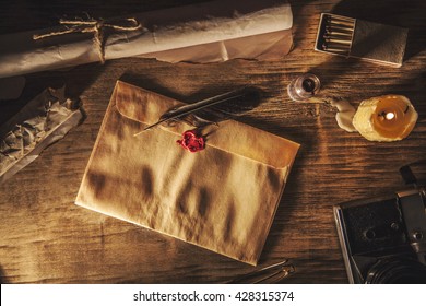 Old feather, envelope and  sealing wax on wooden table