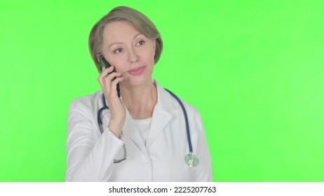 Old Female Doctor Talking On Phone On Green Background