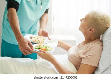 Old Female Taking Breakfast From Worker Of Hospital